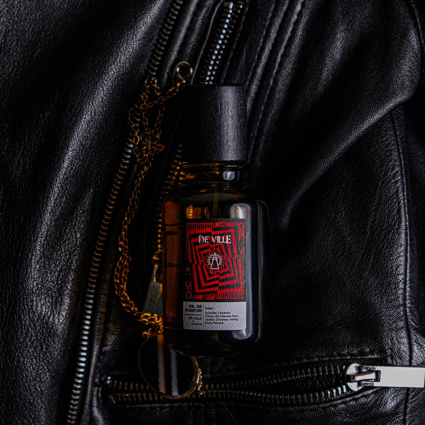 Bottle of De Vie skincare product on a black leather jacket